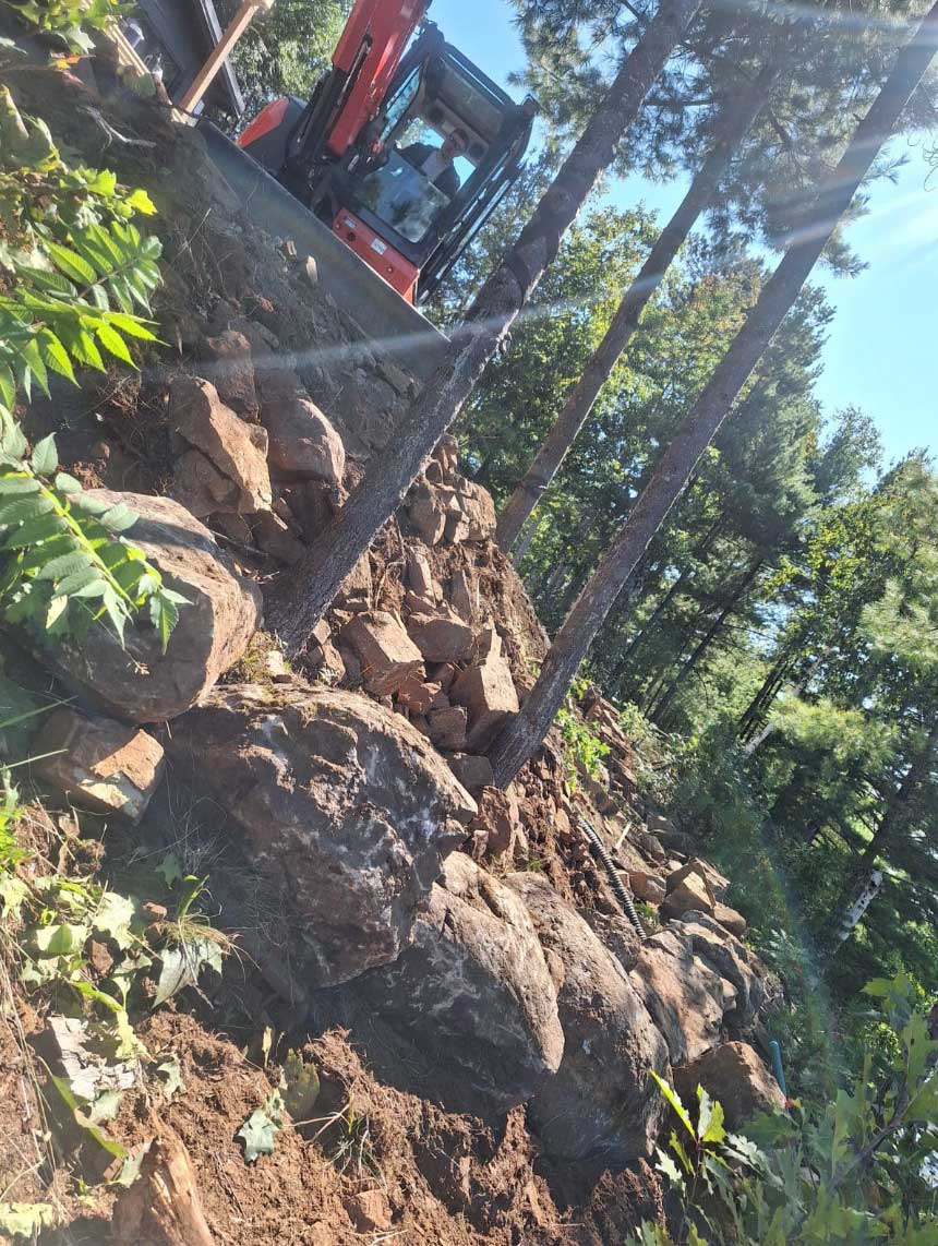 Excavator on a steep, rocky job site