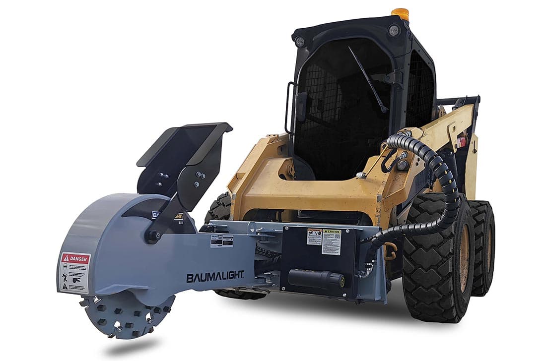 Skid steer with stump grinder attachment removing a tree stump